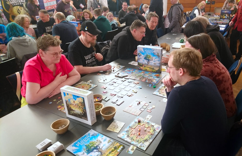 Spieltische mit spielenden Personen am Stand der Game Builders auf den Spieletagen Ratingen 2024